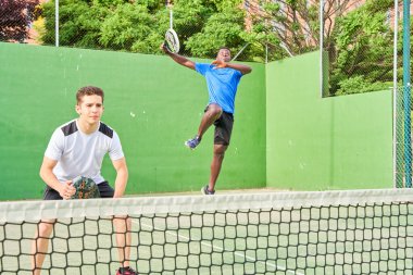 Sahada raket oynayan iki genç arkadaş. Spor konsepti. Boşluğu kopyala