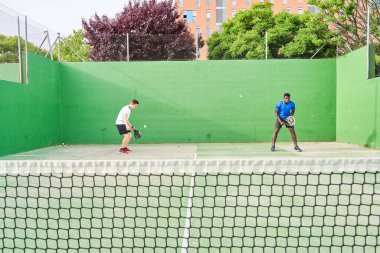 Sahada raket oynayan iki genç arkadaş. Spor konsepti. Boşluğu kopyala