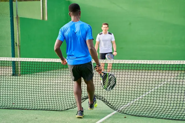 Sahada raket oynayan iki genç arkadaş. Spor konsepti. Boşluğu kopyala