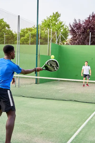 Sahada raket oynayan iki genç arkadaş. Spor konsepti. Boşluğu kopyala