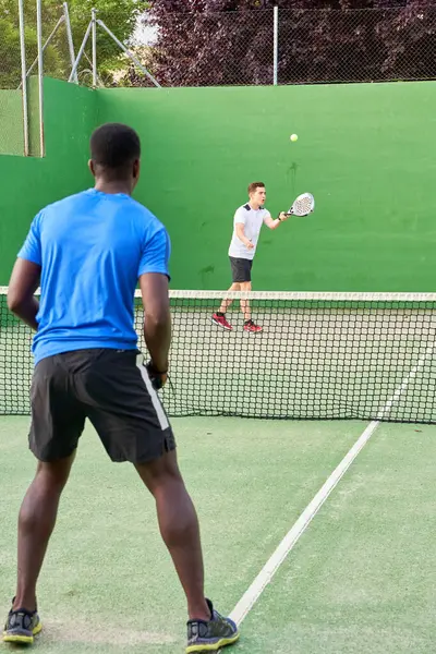 Sahada raket oynayan iki genç arkadaş. Spor konsepti. Boşluğu kopyala