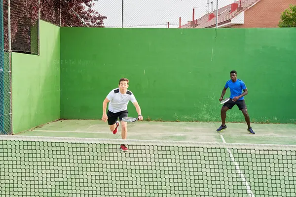 Sahada raket oynayan iki genç arkadaş. Spor konsepti. Boşluğu kopyala