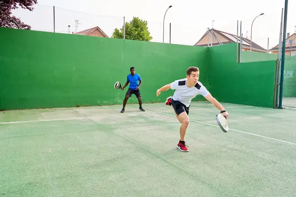 Sahada raket oynayan iki genç arkadaş. Spor konsepti. Boşluğu kopyala