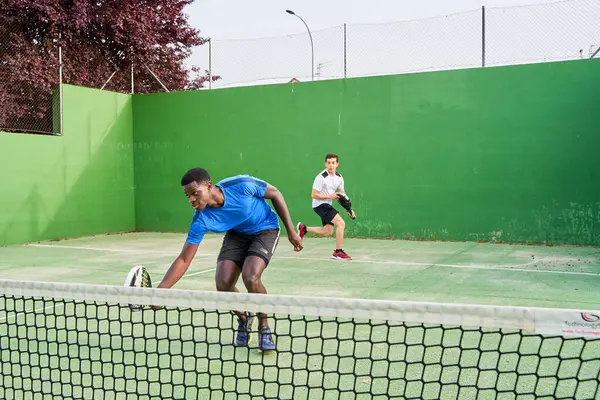 Sahada raket oynayan iki genç arkadaş. Spor konsepti. Boşluğu kopyala