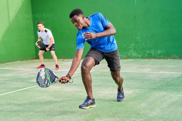 Sahada raket oynayan iki genç arkadaş. Spor konsepti. Boşluğu kopyala