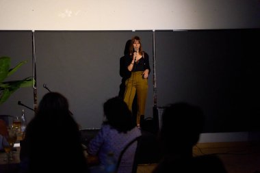 Alternatif bir tiyatroda seyircilerle birlikte sahnede bir monolog sunan kadın sanatçı.