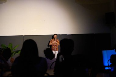 Seyircilerle loş aydınlatılmış bir tiyatroda erkek oyuncu monolog yapıyor.