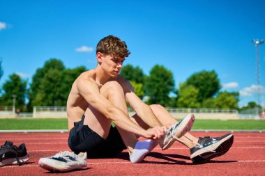 Ayakları destekli bir adam yerde oturuyordu. Bir çift Nike ayakkabısı giyiyor.