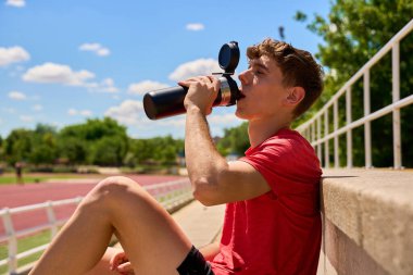 Teneffüste şişeden su içen sporcu