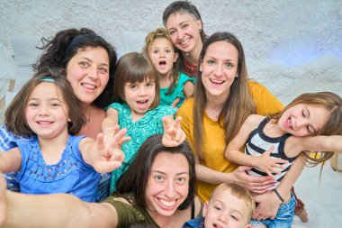 Close-up of mothers and children smiling and taking a selfie in a salt cave during halotherapy session clipart