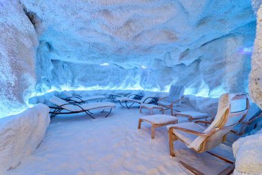 Salon sandalyeleri ve atmosferik ışıklandırması olan bir tuz mağarası.