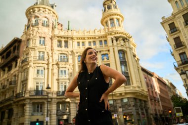 Şehirdeki tarihi bir binanın önünde poz veren kadın.