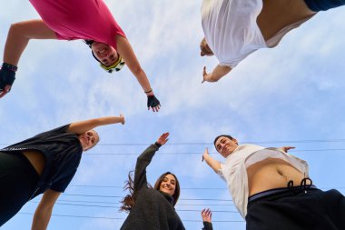 Bir grup patenci aşağıdan izlenen kollarını kaldırarak kutluyorlar.