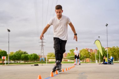 Genç adam parkta otururken elma yiyor.