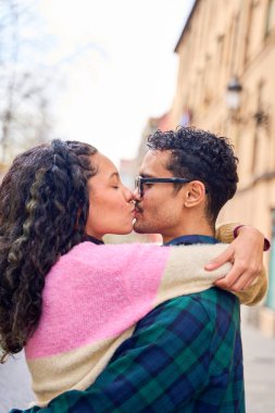 Açık havada öpüşen romantik çift, şehir ortamında aşkı ve bağlantıyı kutluyor.
