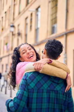 Genç, çok ırklı bir çift Avrupa 'daki tatillerinde gülüyor ve kucaklaşıyorlar.