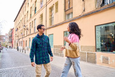 İki turist, büyüleyici bir kaldırım taşı caddesinde yürürken canlı Madrid 'i keşfederek muhabbetin tadını çıkarıyorlar.