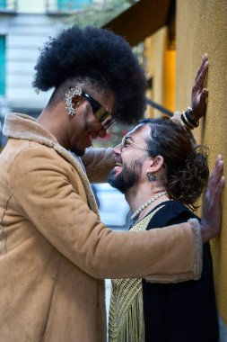 İki çift cinsiyetli, çift cinsiyetli olmayan insan bir şehir caddesinde hassas bir anı paylaşıyorlar, sevgilerini ve sevgilerini ifade ediyorlar.