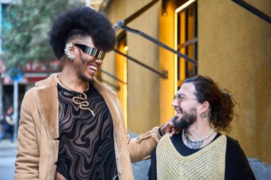 İki şık, ikili olmayan insan bir güler ve bir şehir caddesinde birbirlerine eşlik etmekten zevk alırlar.