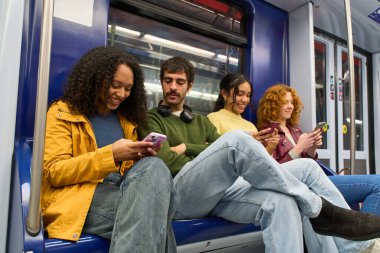 Öğrenciler metroda seyahat ederken, arkadaşlarıyla iletişim kurarken ve seyahatleri sırasında sosyal medyada gezinirken akıllı telefonlarla meşgul oluyorlar.