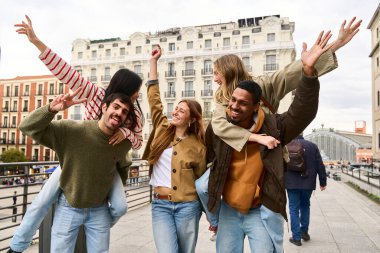 Neşeli, çoklu etnik çeşitliliğe sahip genç arkadaşlar şehir merkezinde gezintiler yapıyorlar. Kaygısız mutluluk ve birlikteliği ifade ediyorlar.