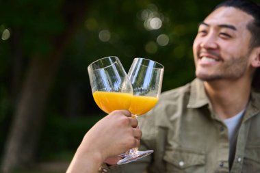 Ellerinde portakal suyu bardakları arka planda gülümseyen bir adamla kadeh kaldırıyorum.