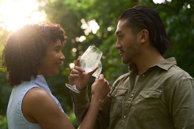 Genç bir çift şarap bardağını tutuyor ve paylaşıyor. Bir üzüm bağında romantik bir anın tadını çıkarıyor. Aşklarını kutluyorlar.