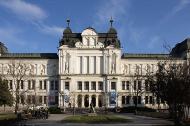 Üzerinde saat kulesi olan büyük bir bina.