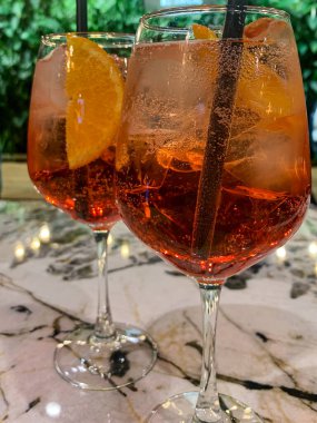 Bir bardak buzlu kırmızı kokteyl ve bir dilim limon.