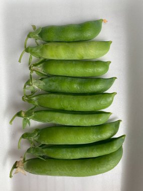 Beyaz arkaplanda yeşil bezelyeler