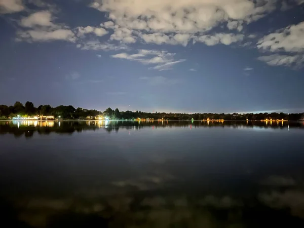 Vista Noturna Lago Qual Nuvens Luzes Costa São Refletidas Exposição — Fotografia de Stock
