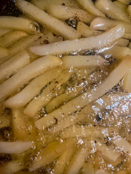 前景を中心に選択的に熱い油風呂でフランスの揚げジャガイモのクローズアップ — ストック写真