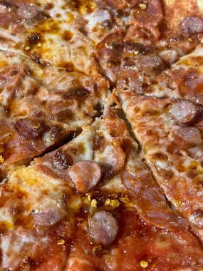 Parmesanlı pizza, acı biber ve dilimlenmiş sosis.