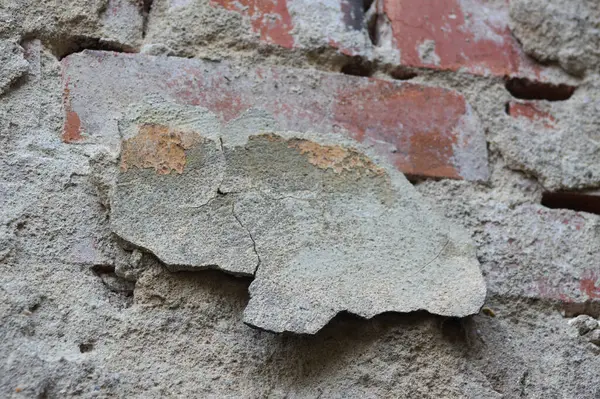 Close-up of brick wall with fallen plaster