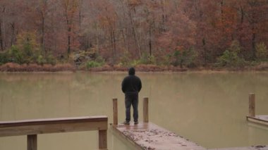 İlham, Yalnız, Yalnız, Zen, Huzurlu, Soğuk - Siyah ceketli tanınmaz adam Göl kenarında duruyor Sonbahar Ağaçları Arkansas