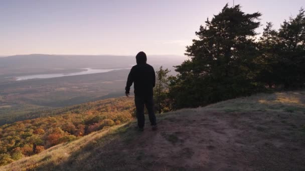 崇高的精神 身披黑衣 难以辨认的人站在山顶上 面对着秋天的落叶树谷 — 图库视频影像