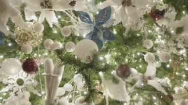 Güzel aydınlatılmış Noel Ağacı Dekorasyonu. Kar Baloları, Mavi Çiçekler, Beyaz Baykuş ve Buz Pateni Süslemeleri. Kapat..