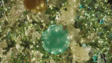 Güzel aydınlatılmış Noel Ağacı Dekorasyonu. Renkli Mavi Yuvarlak Toplar, Altın Kurdeleler, Denizyıldızı ve Deniz Kabuğu Süslemeleri. Kapat..