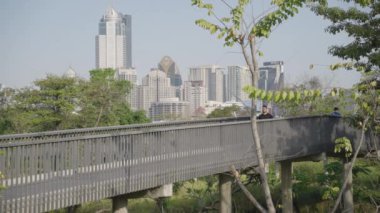 Man Running at Benjakitti Benchakitti Forest Park, Bangkok Thailand Skyline on Background Morning in Slow Motion
