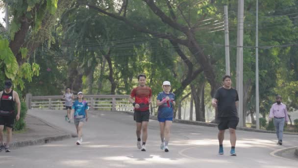 人々の運動の朝は ルンピニー ルンピニー公園でジョギングを実行していますバンコク 健康的なライフスタイルスローモーション — ストック動画