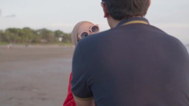 Happy Modern Muslim Southeast Asian Indonesian Family Enjoying Sunset Together on The Beach. Silhouette of Father Mother and Child in Slow Motion.