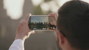 Travel Tourist Taking Photo of Angkor Wat in The Morning with Smartphone Slow Motion
