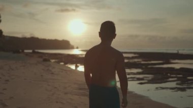 Man looking at Sun on the Beach Showing Hope, Optimism, Freedom, Happiness