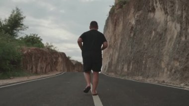 Büyük XL Büyük Adam Ağır Çekimde Kayalar Duvarı Arasında Koşuyor