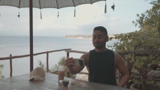 Digital Nomad Male Guy Videocall Smartphone Cafe Beach Bali Indonesia — 图库视频影像