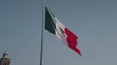 Mavi Gök 'te Meksika Ulusal Bayrağının Yavaş Hareketi - Beyaz Şerit' in merkezinde Ulusal Silahlar Birliği ile birlikte Yeşil, Beyaz ve Kırmızı Üçlemenin Dikey Üçlemesi