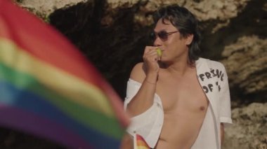 Koyu Derili Güneydoğu Asya LGBT Gay Adam Gökkuşağı Gururlu Piknik Battaniyesiyle Sahilde Oturuyor