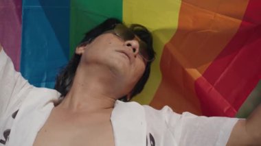 Koyu Derili Güneydoğu Asya LGBT Gay Adam Gökkuşağı Gurur Bayraklarıyla Sahilde Dans Ediyor