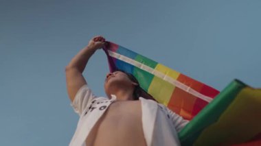 Koyu Derili Güneydoğu Asya LGBT Gay Adam Gökkuşağı Gurur Bayraklarıyla Sahilde Dans Ediyor