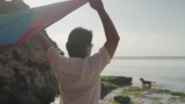 Koyu Derili Güneydoğu Asya LGBT Gay Adam Gökkuşağı Gurur Bayraklarıyla Sahilde Dans Ediyor